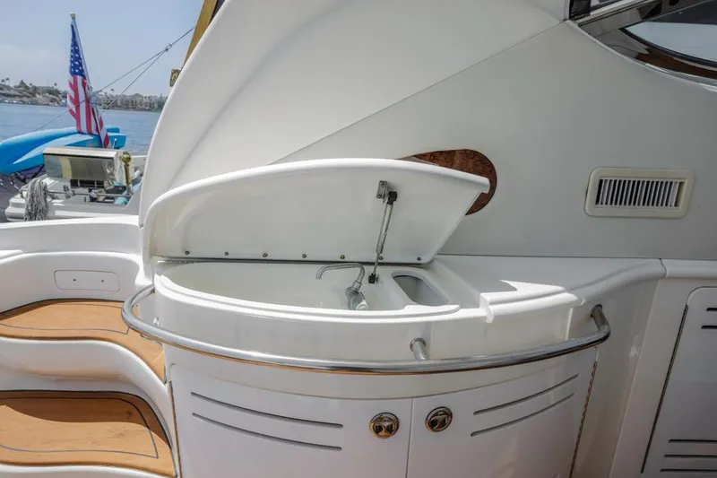 Slide: The Image of Outdoor sink area on 2000 Sea Ray 510 Sundancer yacht, with American flag in background. - 26