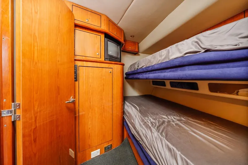 Slide: The Image of Interior cabin of 2000 Sea Ray 510 Sundancer with wooden cabinetry and bunk beds. - 37