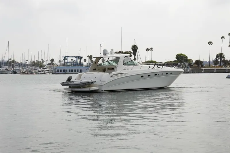 Slide: The Image of 2000 Sea Ray 510 Sundancer yacht cruising in a marina with palm trees in the background. - 5