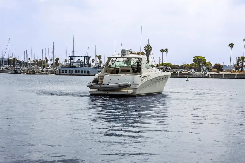 Slide: The Image of Sea Ray 510 Sundancer 2000 yacht cruising in a marina with palm trees and docks. - 7