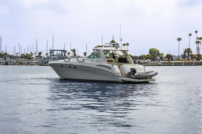 Slide: The Image of Sea Ray 510 Sundancer 2000 yacht on calm water near marina with palm trees. - 9