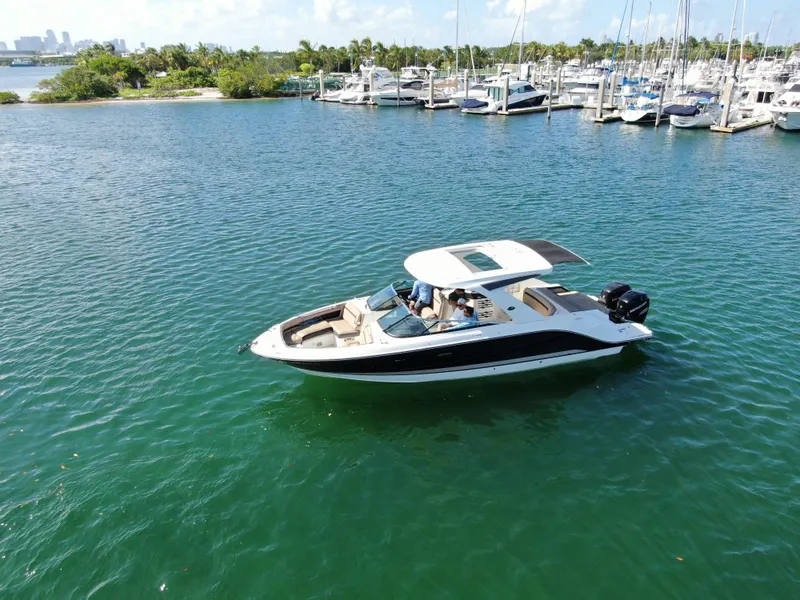 Slide: The Image of 2018 Sea Ray 310 SLX boat cruising on a serene marina with lush greenery. - 0