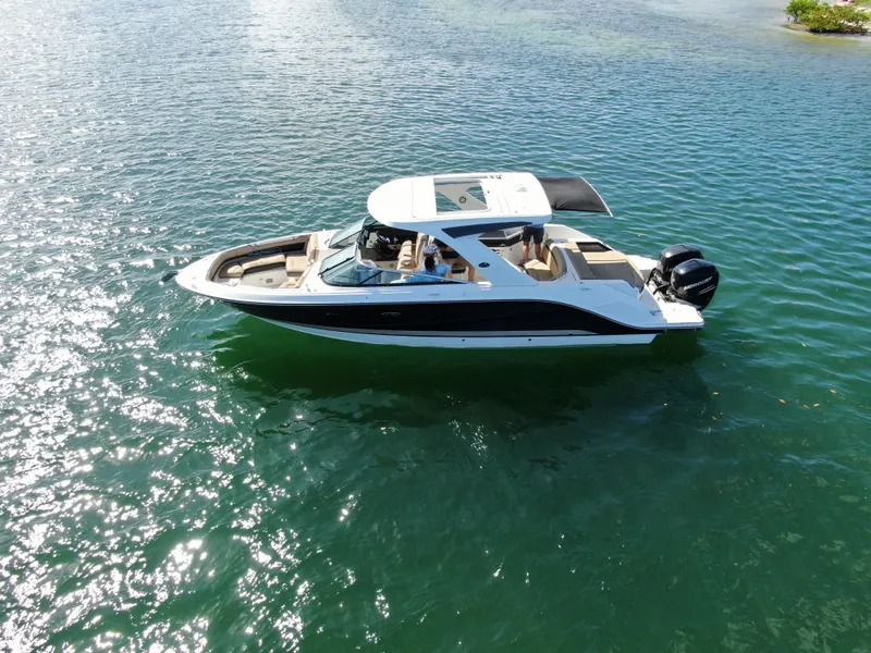 Slide: The Image of 2018 Sea Ray 310 SLX boat cruising on clear, sunny waters. - 10