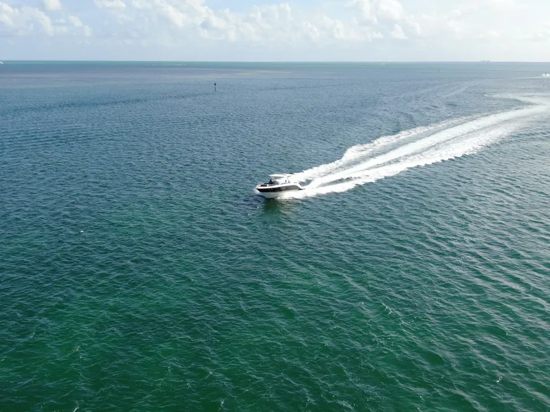 Slide: The Image of 2018 Sea Ray 310 SLX cruising on open water under a clear sky. - 13