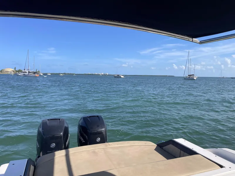 Slide: The Image of 2018 Sea Ray 310 SLX boat on water, view of ocean and distant sailboats. - 18
