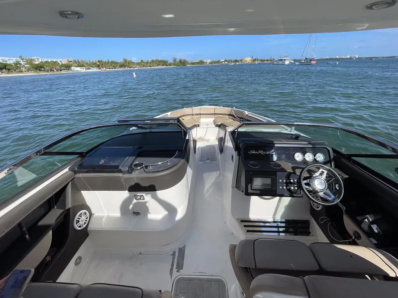 Slide: The Image of 2018 Sea Ray 310 SLX boat interior with steering wheel, dashboard, and open water view. - 20