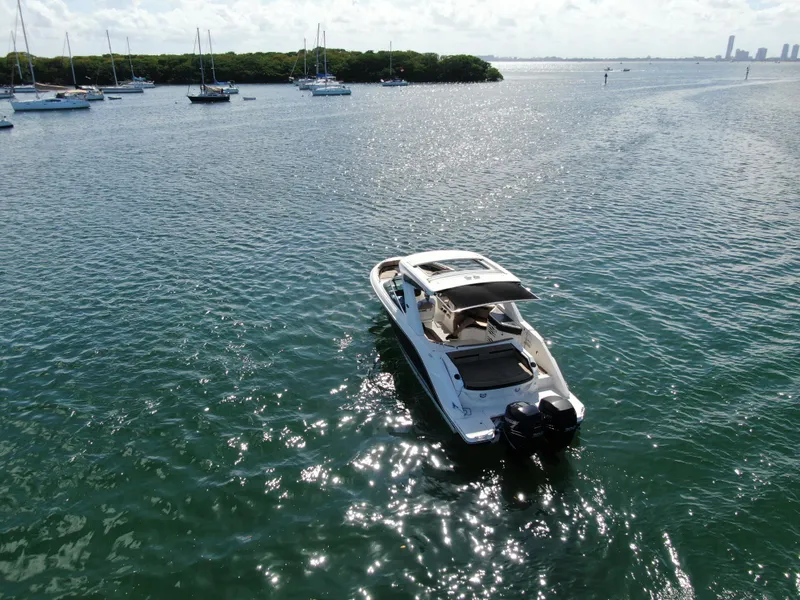 Slide: The Image of 2018 Sea Ray 310 SLX boat cruising on a sunny, calm sea with sailboats in the background. - 4