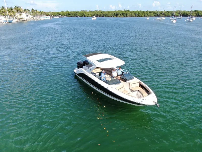Slide: The Image of 2018 Sea Ray 310 SLX boat cruising on a sunny, calm waterway. - 7