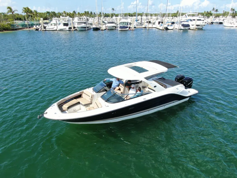 Slide: The Image of 2018 Sea Ray 310 SLX boat cruising on a sunny day near a marina. - 9