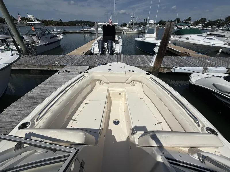 Slide: The Image of 2017 Grady-White Freedom 275 boat docked at marina, showcasing spacious deck and seating. - 10