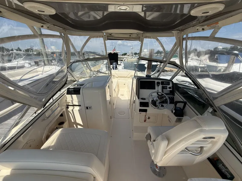 Slide: The Image of 2017 Grady-White Freedom 275 boat interior with helm, seating, and clear canopy. - 11