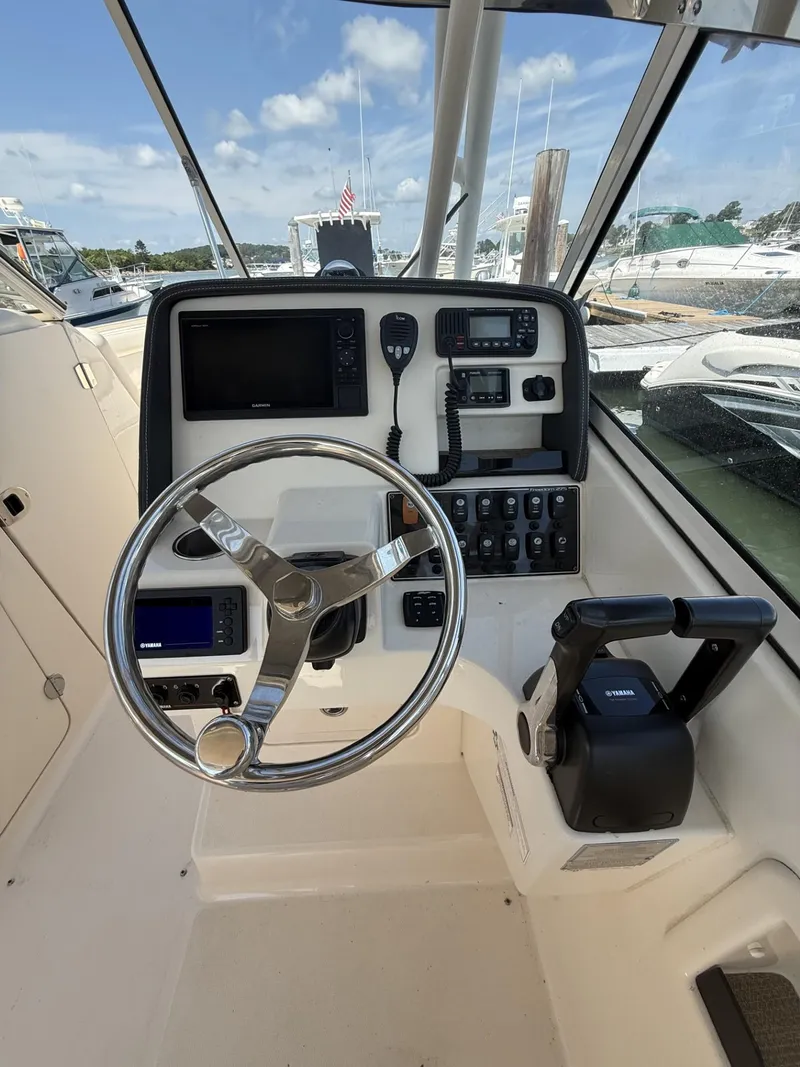 Slide: The Image of 2017 Grady-White Freedom 275 boat helm with steering wheel and control panel. - 12