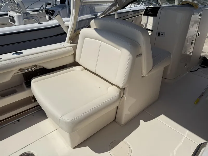 Slide: The Image of 2017 Grady-White Freedom 275 boat interior with white seating and helm area. - 14