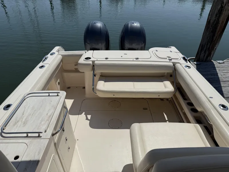 Slide: The Image of 2017 Grady-White Freedom 275 boat interior with dual engines, docked on calm water. - 15