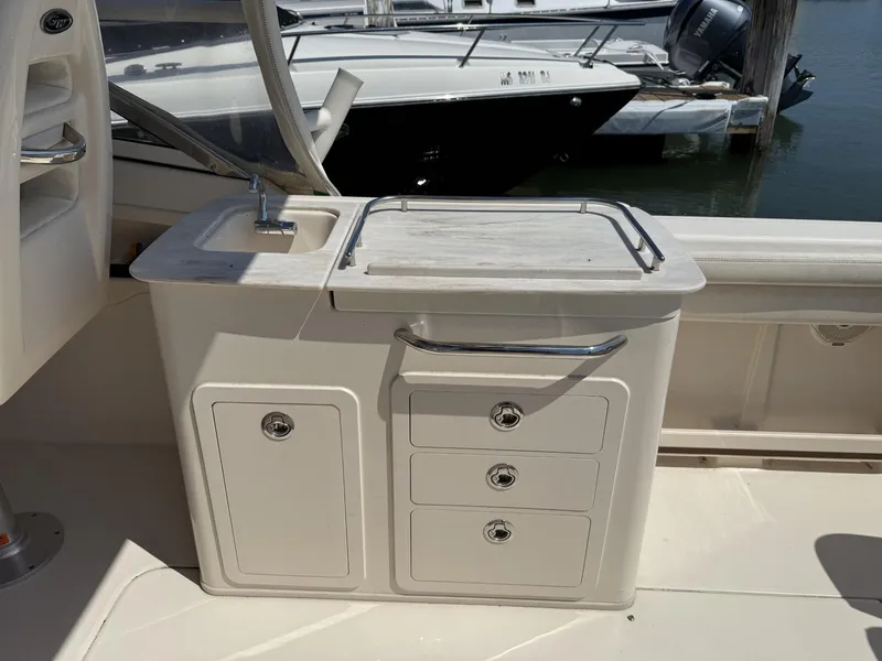 Slide: The Image of 2017 Grady-White Freedom 275 boat interior with sink and storage drawers. - 16