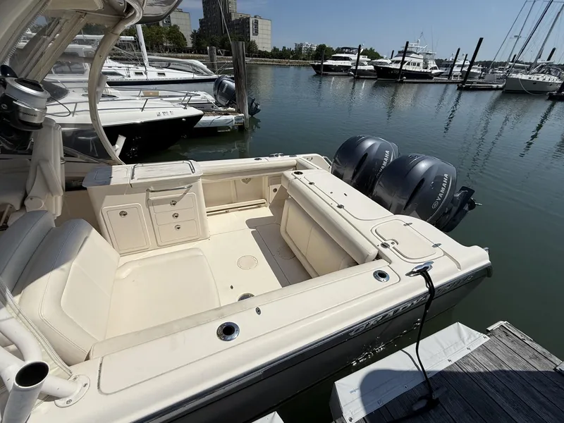 Slide: The Image of 2017 Grady-White Freedom 275 boat docked, featuring dual Yamaha engines and spacious seating. - 17