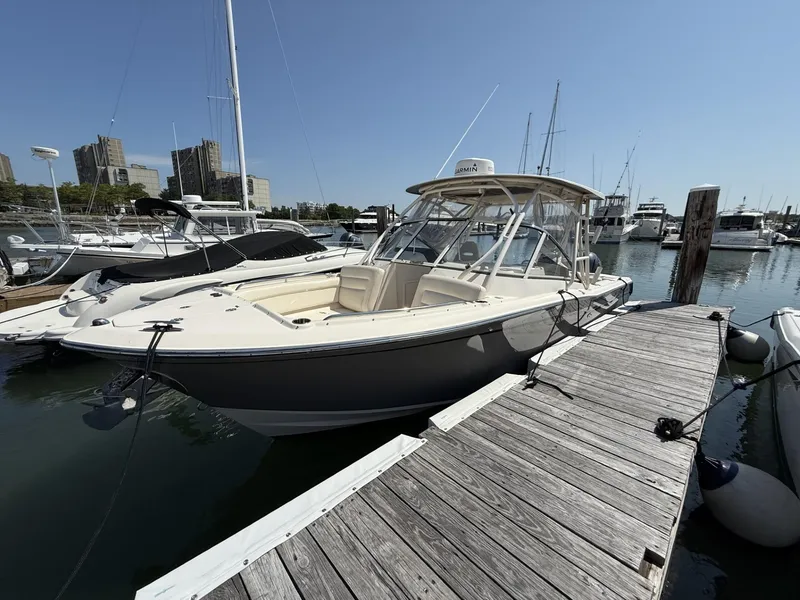 Slide: The Image of 2017 Grady-White Freedom 275 boat docked at marina under clear blue sky. - 8