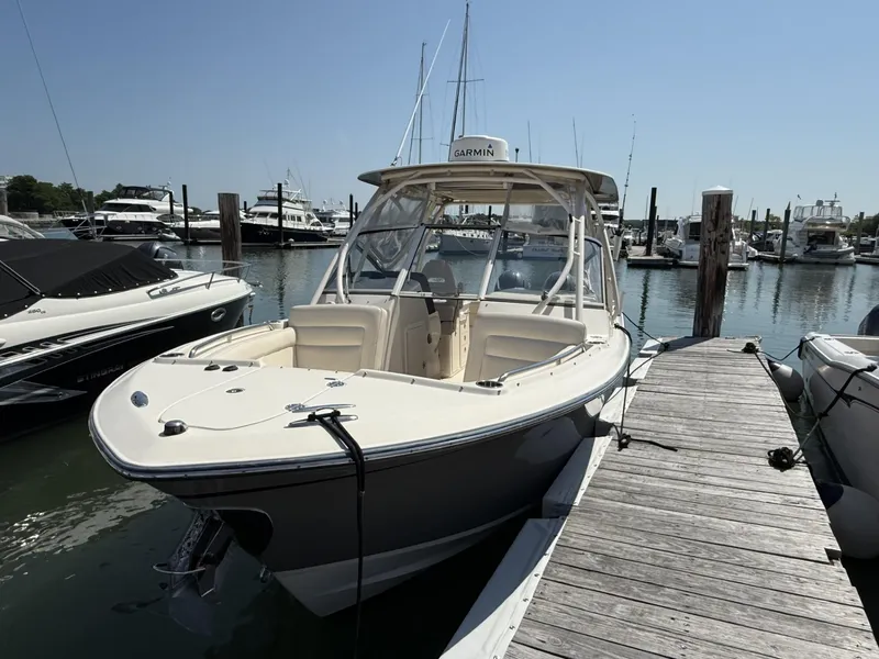Slide: The Image of 2017 Grady-White Freedom 275 boat docked at marina, clear sky background. - 9