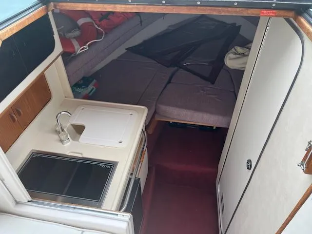 Slide: The Image of Interior of 1992 Sea Ray 310 Amberjack boat with kitchenette and seating area. - 12