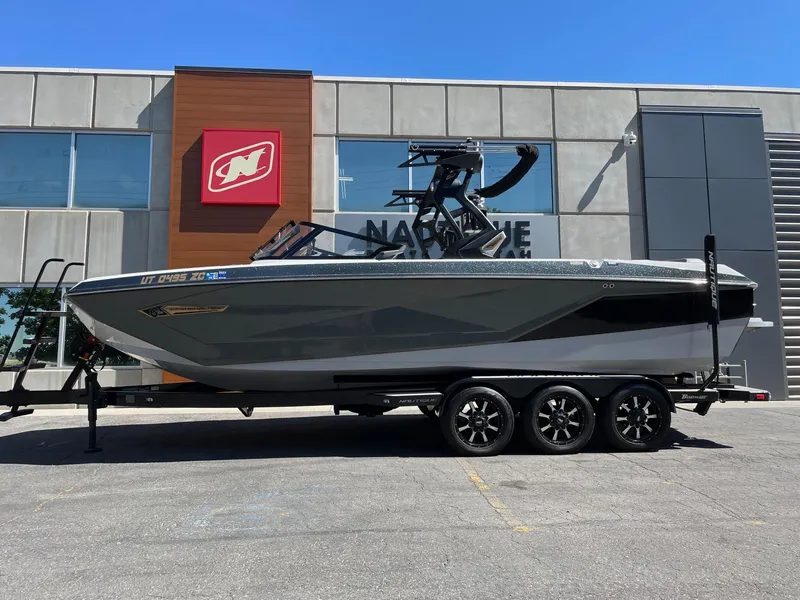 The Image of 2021 Nautique Super Air Nautique G25 boat on trailer outside dealership. - 1