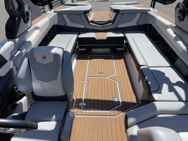 Slide: The Image of 2021 Nautique Super Air Nautique G25 interior with luxurious seating and teak flooring. - 12