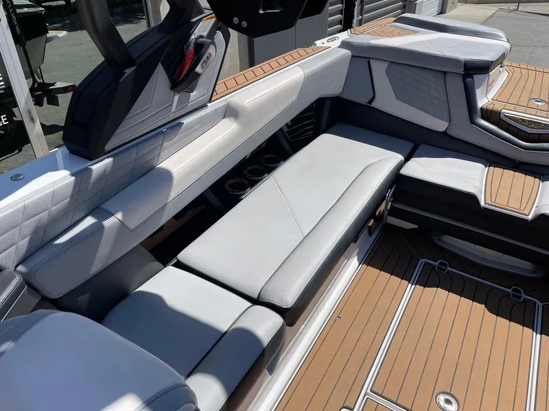 Slide: The Image of 2021 Nautique Super Air Nautique G25 interior with luxurious seating and teak flooring. - 7