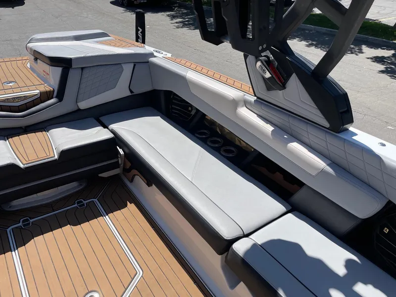 Slide: The Image of 2021 Nautique Super Air Nautique G25 interior with luxurious seating and teak flooring. - 9