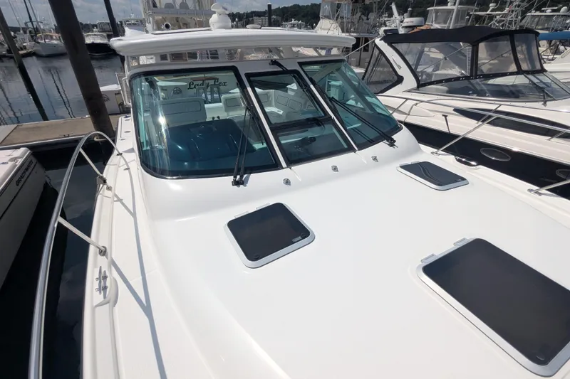 Slide: The Image of 2005 Tiara Yachts 3200 Open docked at marina, showcasing sleek design and spacious deck. - 15