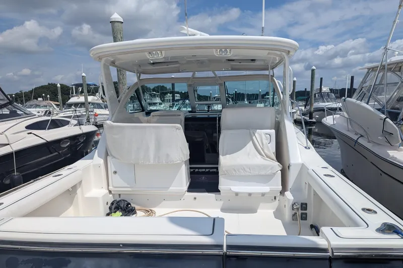 Slide: The Image of 2005 Tiara Yachts 3200 Open at marina, featuring spacious deck and seating. - 16