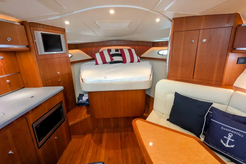 Slide: The Image of Luxurious 2005 Tiara Yachts 3200 Open cabin interior with bed, seating, and wooden cabinetry. - 17
