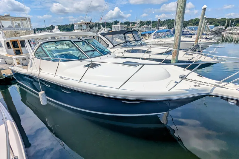Slide: The Image of 2005 Tiara Yachts 3200 Open docked in a marina under a blue sky. - 2