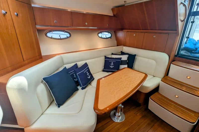 Slide: The Image of 2005 Tiara Yachts 3200 Open interior with cozy seating and nautical-themed cushions. - 21