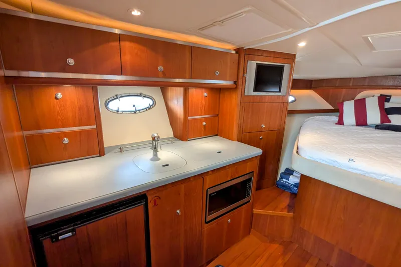 Slide: The Image of Luxurious 2005 Tiara Yachts 3200 Open interior with kitchenette and cozy sleeping area. - 25