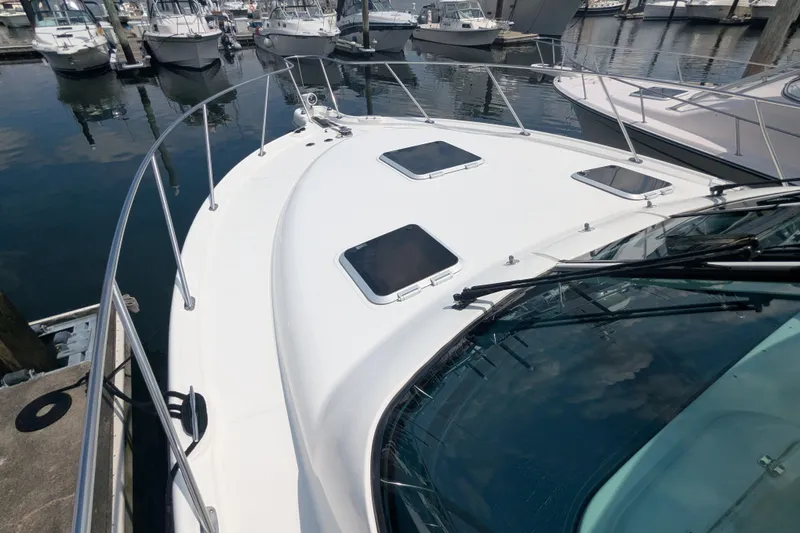 Slide: The Image of 2005 Tiara Yachts 3200 Open docked at marina, showcasing sleek design and spacious deck. - 28