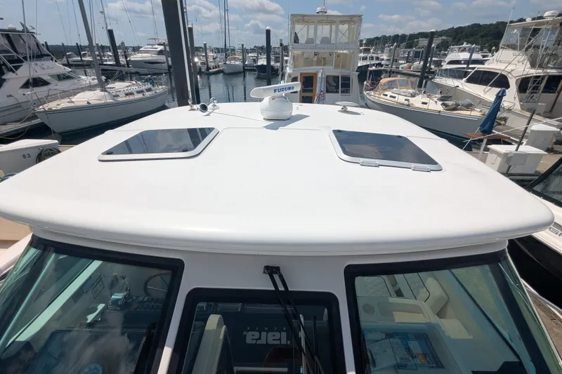 Slide: The Image of 2005 Tiara Yachts 3200 Open at marina, showcasing sleek design and spacious deck. - 30