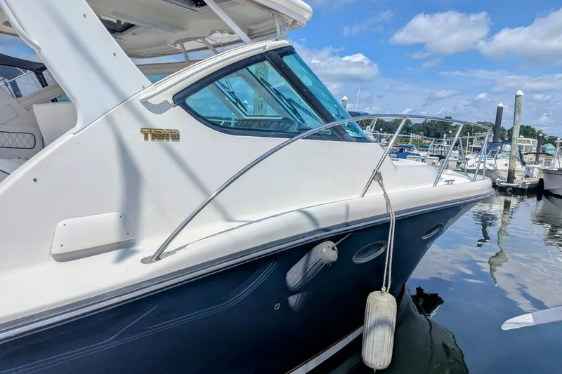 Slide: The Image of 2005 Tiara Yachts 3200 Open docked at marina, featuring sleek design and clear blue skies. - 4