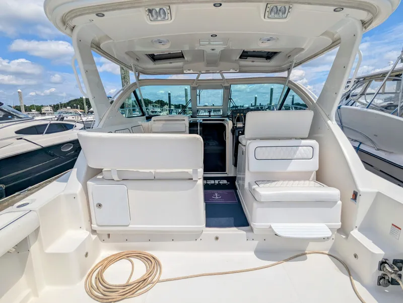 Slide: The Image of 2005 Tiara Yachts 3200 Open interior with seating and helm, docked at marina. - 7