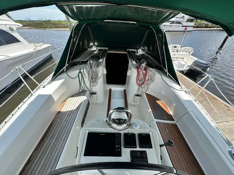 Slide: The Image of Cockpit view of a 1998 Beneteau 381 sailboat, featuring navigation equipment and moored at a marina. - 11