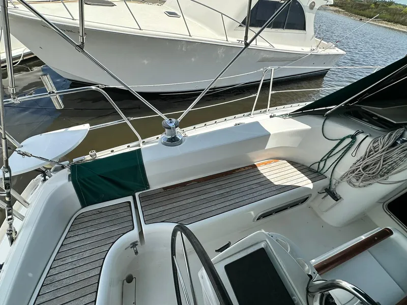Slide: The Image of Cockpit view of a 1998 Beneteau 381 sailboat with wooden deck and mooring ropes. - 13