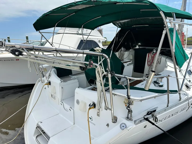Slide: The Image of 1998 Beneteau Oceanis 381 sailboat with green canopy docked at marina. - 16