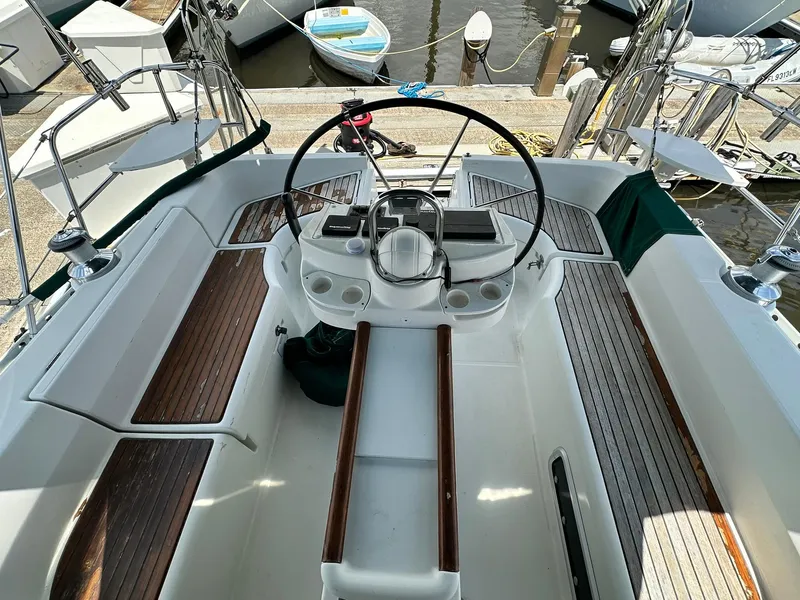 Slide: The Image of Cockpit of a 1998 Beneteau 381 sailboat with wooden seating and steering wheel. - 18