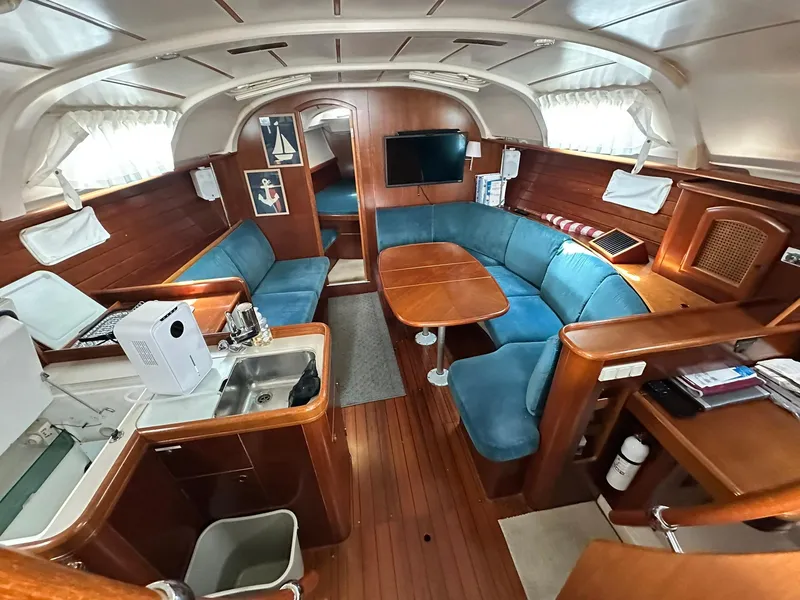 Slide: The Image of Interior of a 1998 Beneteau 381 sailboat with wood finish and blue seating. - 24