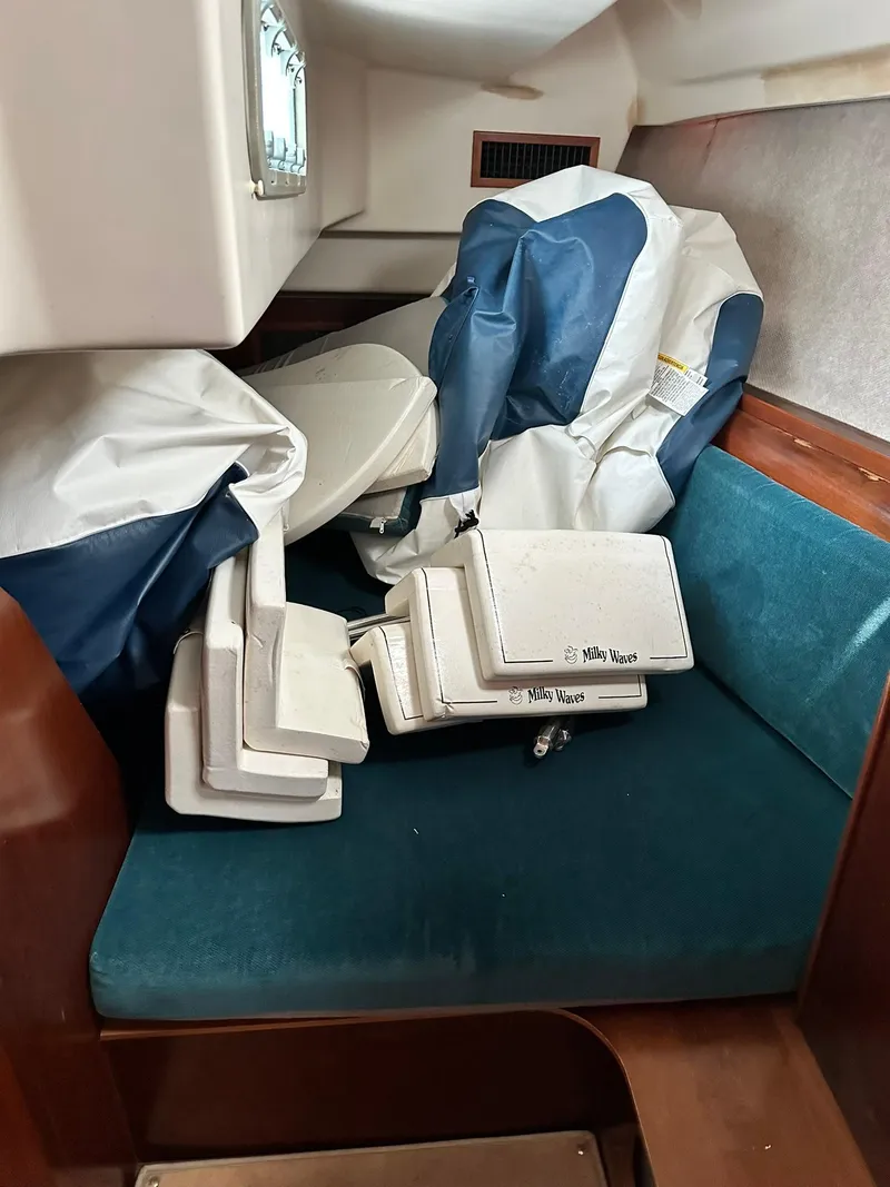 Slide: The Image of Interior of a 1998 Beneteau 381 sailboat with stored equipment and cushions. - 25