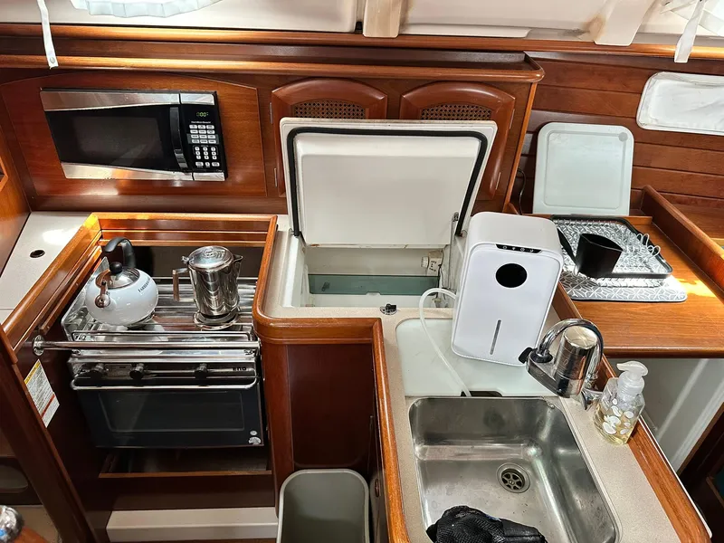 Slide: The Image of Galley kitchen in 1998 Beneteau 381 sailboat with stove, sink, and microwave. - 28