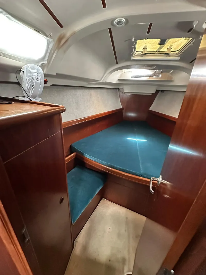 Slide: The Image of 1998 Beneteau 381 cabin interior with wooden finish and blue cushions. - 35