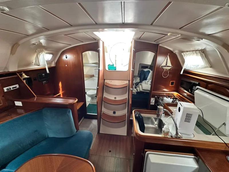 Slide: The Image of Interior of a 1998 Beneteau 381 sailboat with wood finish and compact kitchen. - 37