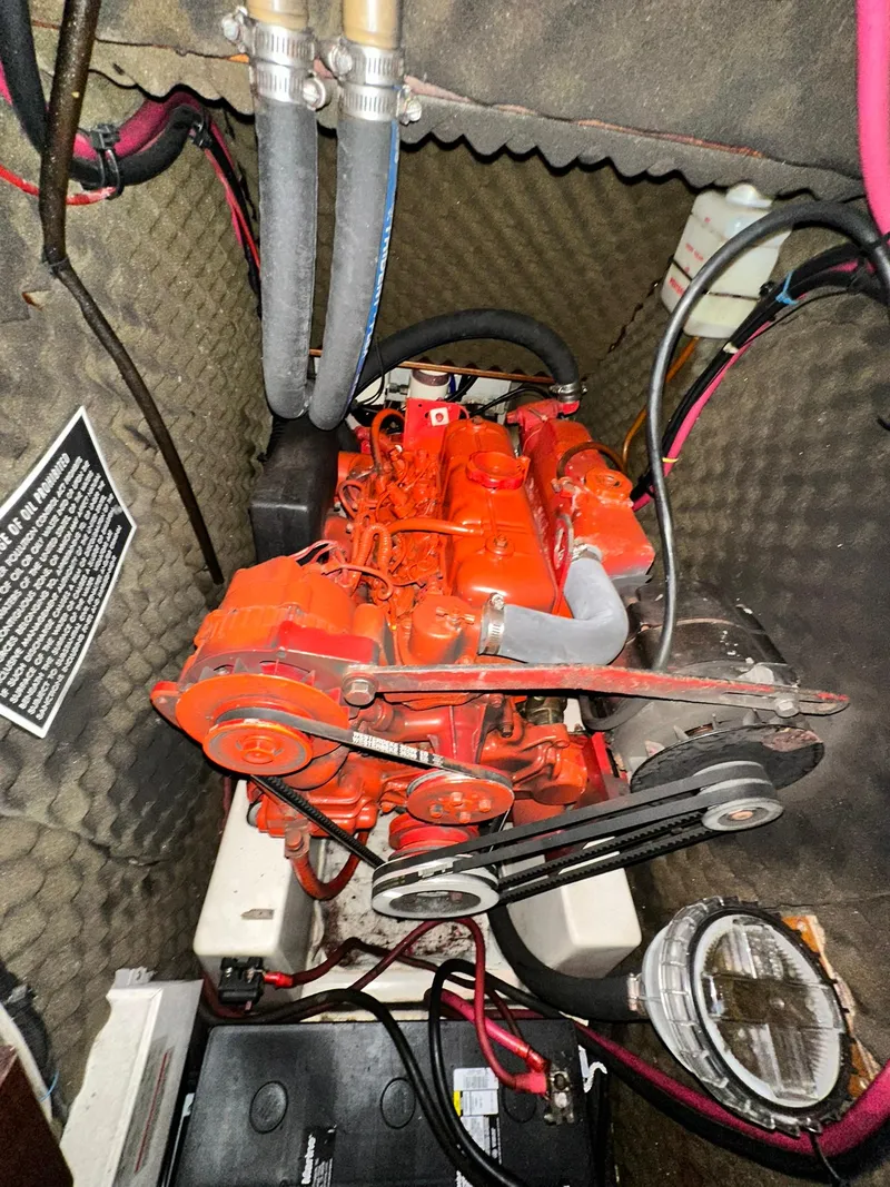 Slide: The Image of Engine compartment of a 1998 Beneteau 381 sailboat, featuring a red marine engine. - 38