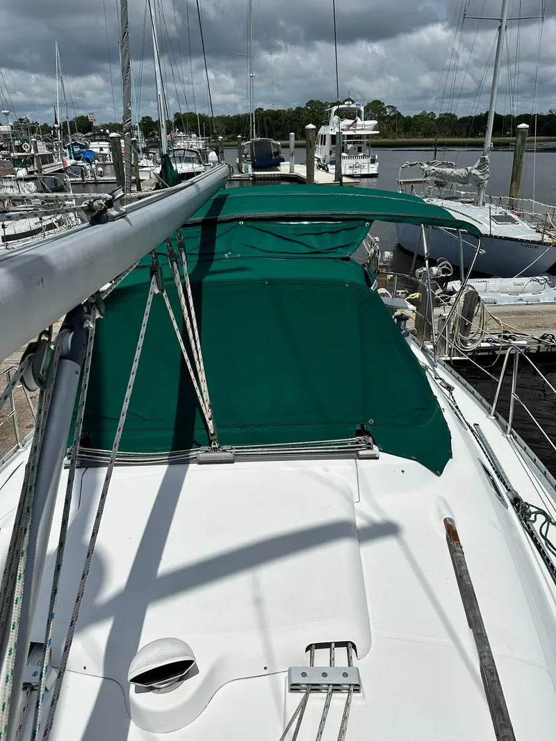 Slide: The Image of Sailboat Beneteau 381, 1998 model, docked with green canopy, overcast sky. - 9