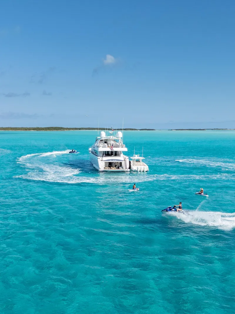 Slide: The Image of Luxurious 2004 Ferretti Yachts 112 Custom Line cruising in turquoise waters with jet skis nearby. - 6