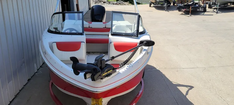 Slide: The Image of 2016 Tahoe 450 TF boat with red and white design, parked outdoors. - 10